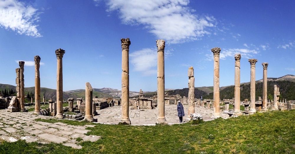 Panoramic view of Djemila (Cuicul), Roman ruins in Algeria — columns and stone arches against a wide sky